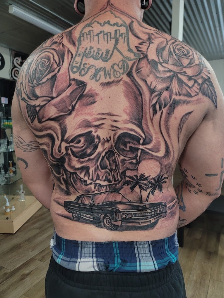 Black and grey skull, roses, and lowrider back piece tattoo done at Soul Stone Tattoo